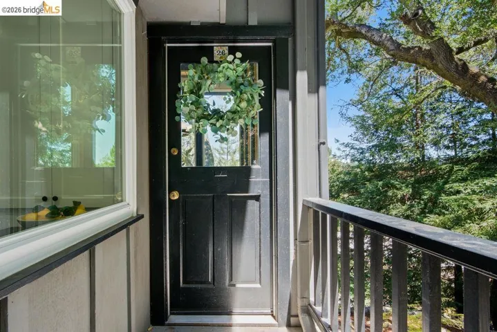 Exterior entry featuring a black door with glass paneling, brass hardware, and vertical siding