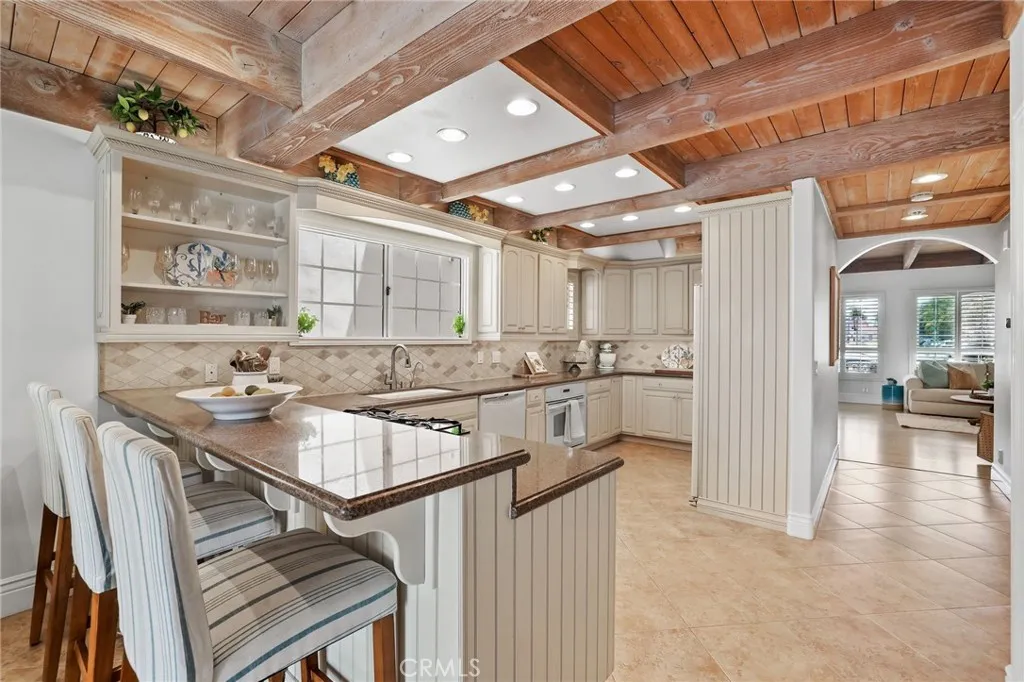 Kitchen with breakfast bar, ample counter space and beautiful beamed ceilings.