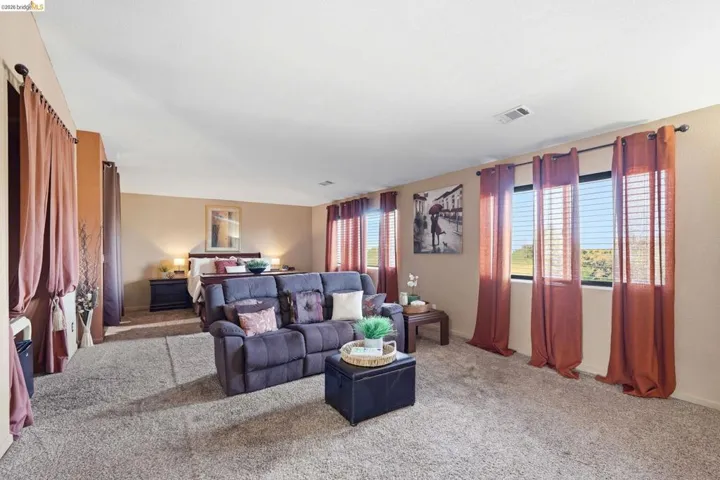 Spacious room featuring neutral carpeting and light tan walls