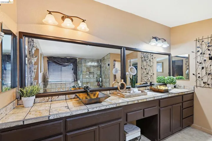 Double vanity with a tiled countertop and dark wood-finish cabinetry