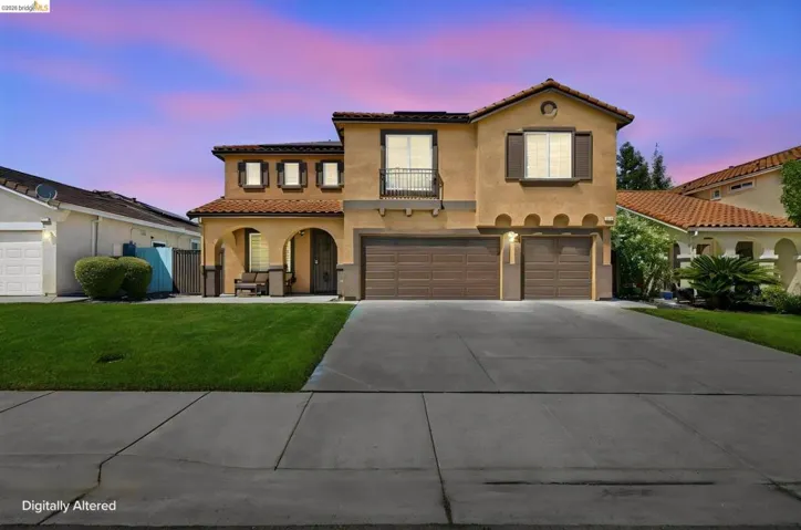 Stucco exterior with a tile roof, an arched entry, a two-car garage, and a single-car garage