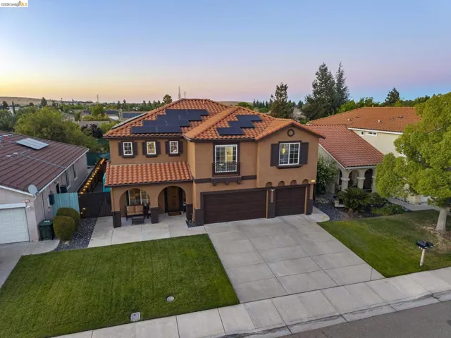 Mediterranean-style residence featuring a tile roof and solar panels