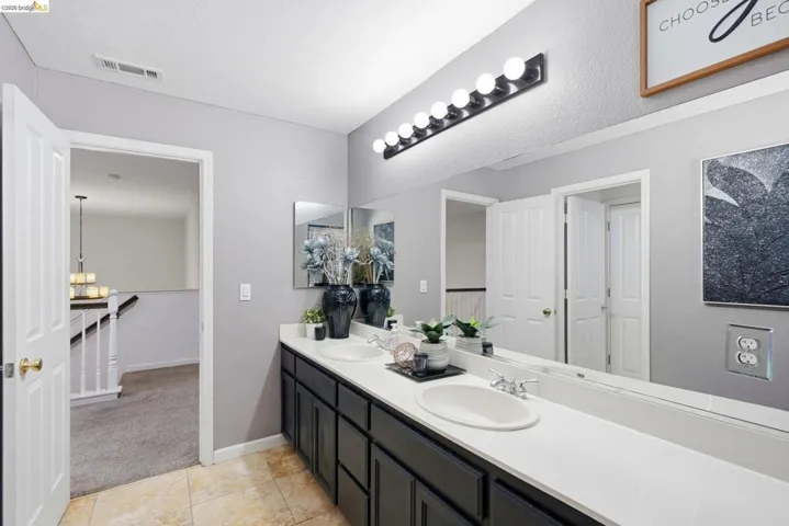 Double vanity with integrated sinks, white countertops, and dark cabinetry