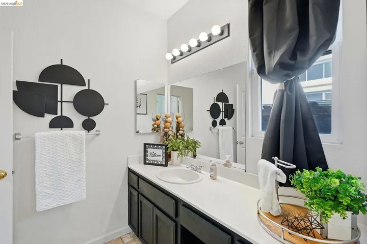 Vanity featuring dark wood cabinetry, white countertop, and integrated sink