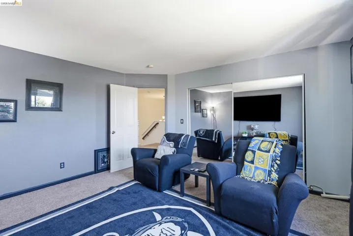 Carpeted room featuring gray walls, white trim, and a white interior door
