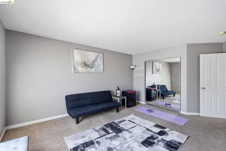 Room featuring light gray painted walls and neutral-toned carpeting