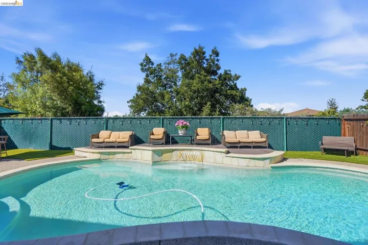 Backyard swimming pool with integrated spa and waterfall feature