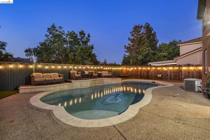 Freeform swimming pool with integrated spa and stone surround