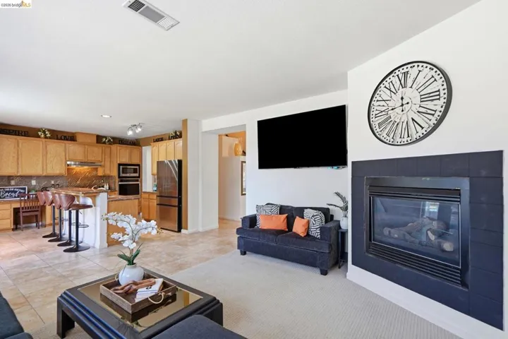 Open-concept living space featuring a fireplace with a dark tile surround