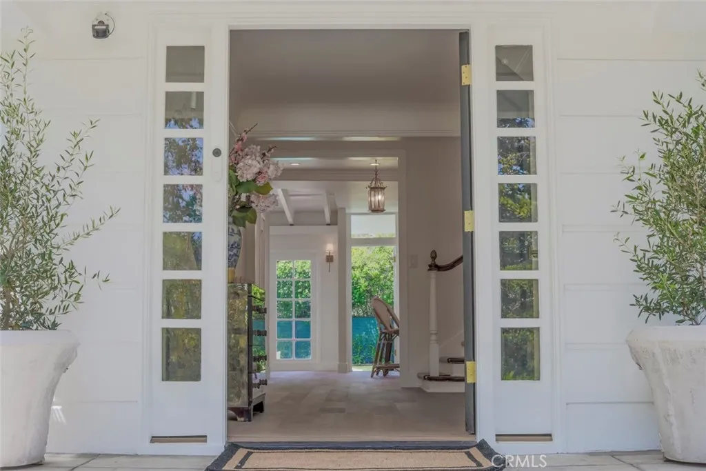 Elegant Entry Foyer with Expansive Views to the Bright Blue Pool and yard