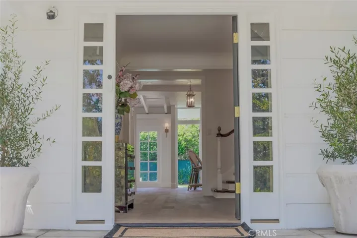 Elegant Entry Foyer with Expansive Views to the Bright Blue Pool and yard