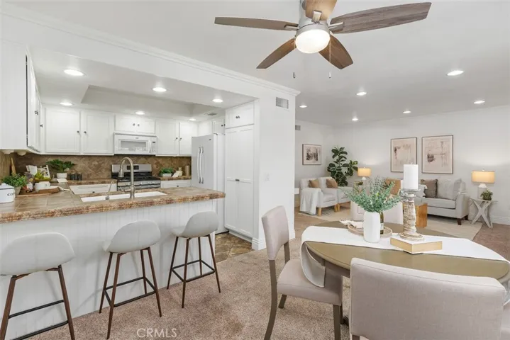 Modernized kitchen with additional bar seating and ceiling fan.