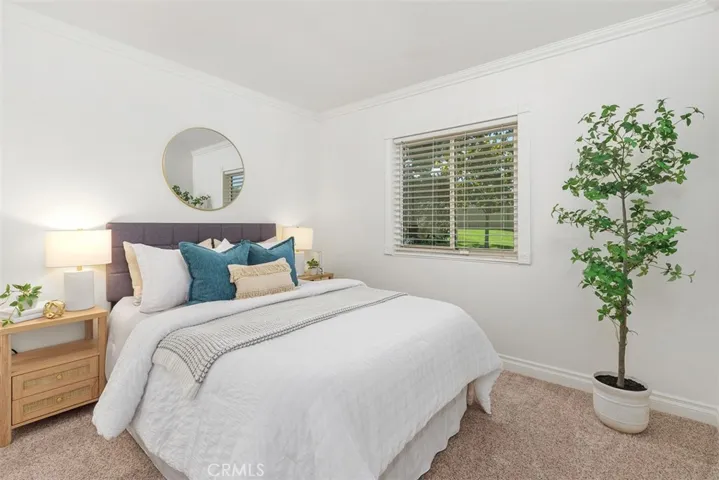 Spacious bedroom with serene views of mature trees.