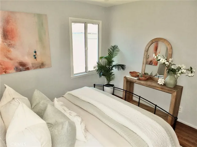 Bright and airy second bedroom with beautiful hardwood floors, new windows, and ceiling fan with light.