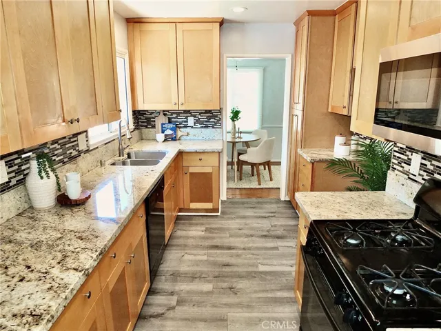 Another view of the remodeled galley kitchen showcasing the new flooring seamlessly leading into the dining room.