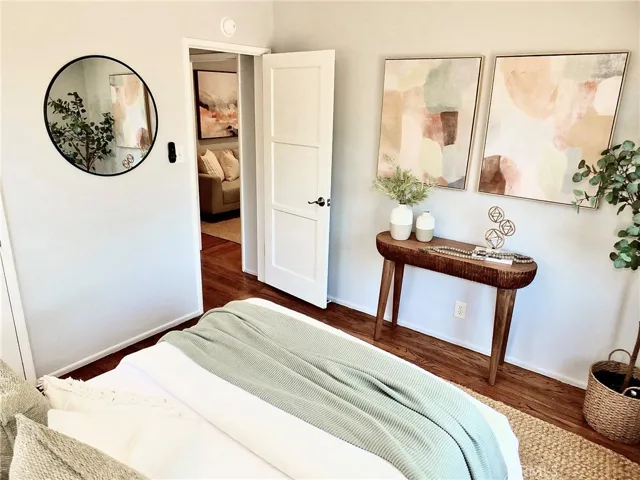 View from the front bedroom looking toward the living room, featuring beautiful hardwood floors.