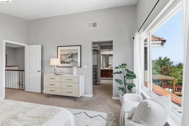 High ceilings in a carpeted room featuring a large window, white trim, and a clear doorway