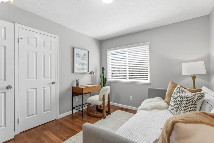 Hardwood flooring extends throughout this room, featuring light gray walls and white trim