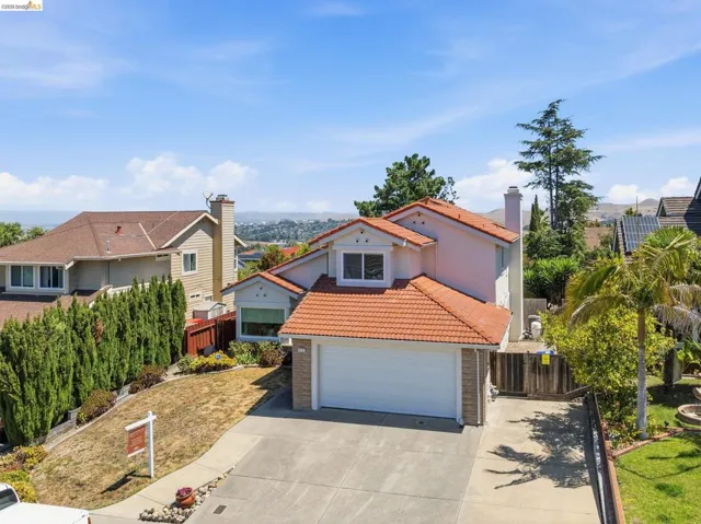Two-story residence featuring a terracotta tile roof, attached garage, and a concrete driveway