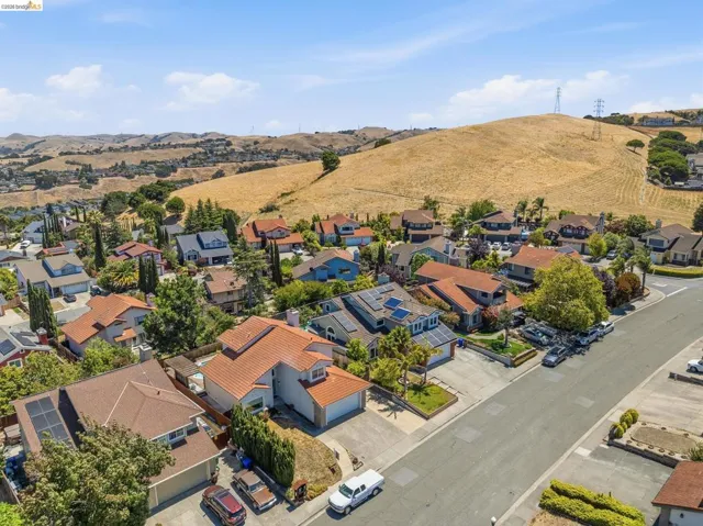 Residential neighborhood with various architectural styles, paved streets, and surrounding hillsides