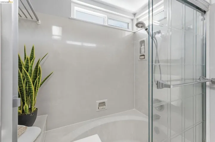Shower and tub combination with a glass enclosure