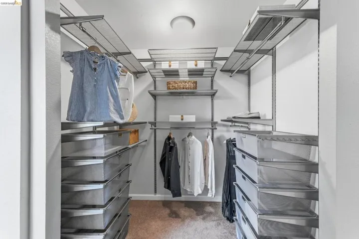 Custom closet system featuring adjustable shelving, multiple hanging rods, and integrated pull-out wire baskets