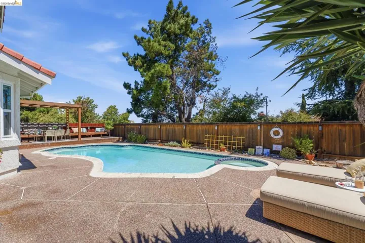Freeform swimming pool with integrated spa, surrounded by expansive aggregate concrete decking