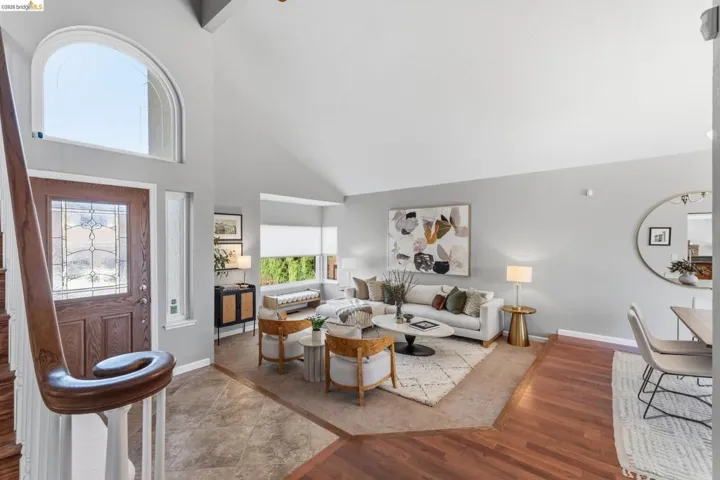 Entry foyer featuring a wood-panel door with leaded glass, an arched transom window, and a grand staircase with a wood handrail