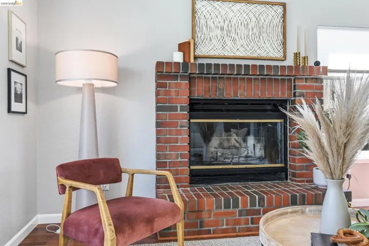 Brick fireplace with a glass-front enclosure, raised hearth, and mantelpiece