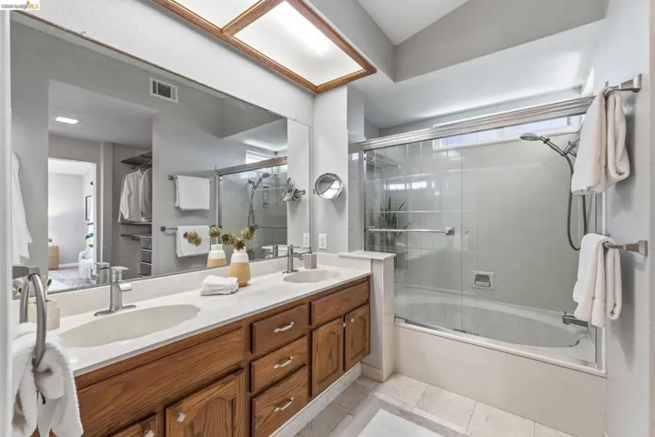 Dual vanity with integrated sinks and brushed nickel faucets, set against a full-width mirror