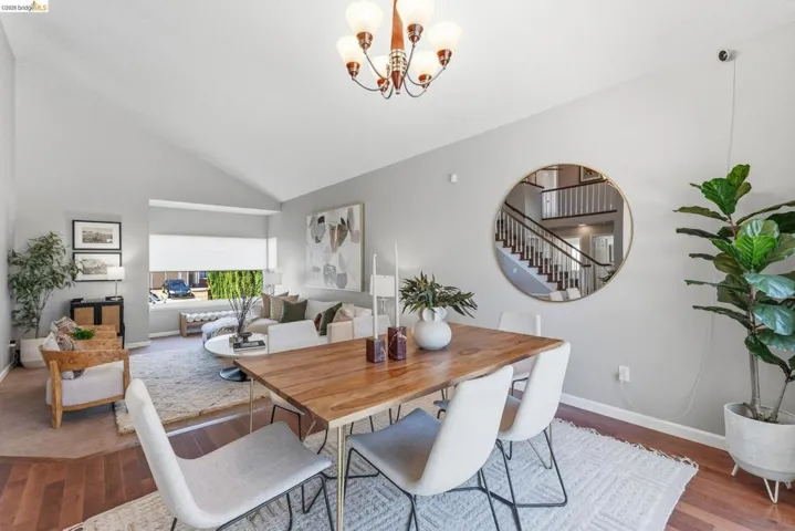 Vaulted ceilings define the living and dining areas, complemented by hardwood-finish flooring in the dining space