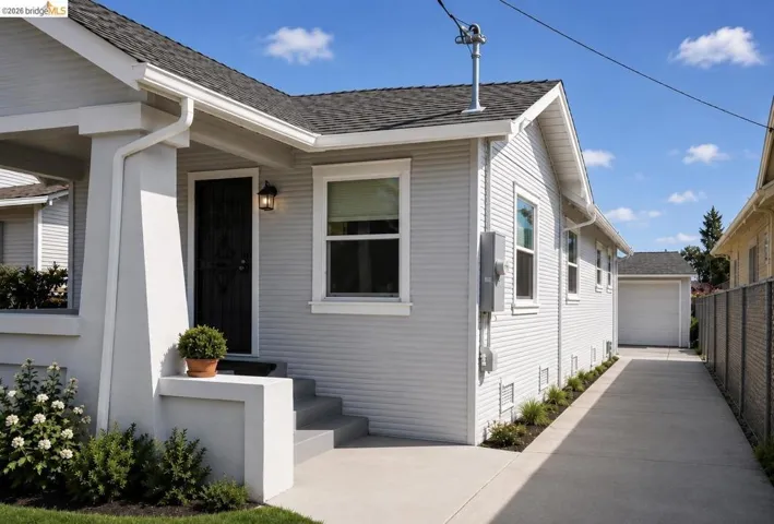 Single-story residence featuring light gray siding, a dark asphalt shingle roof, and white window trim
