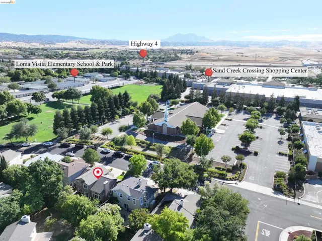 Aerial perspective highlighting the property's proximity to a public park, a shopping center, and a major highway