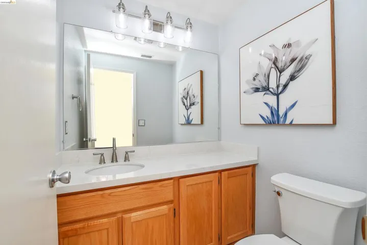 Bathroom vanity featuring a light-toned countertop with an undermount sink and brushed nickel faucet