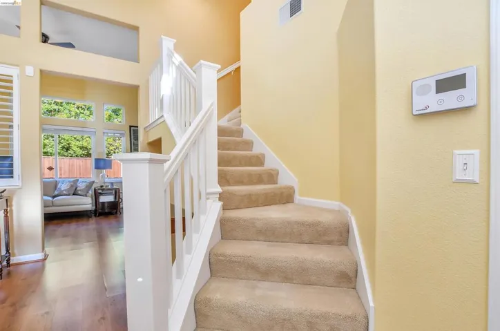 Carpeted staircase with white balusters and newel posts