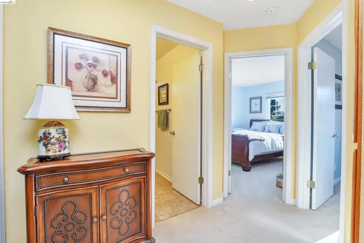 Hallway featuring carpeted flooring and light yellow walls