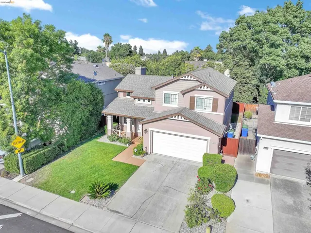 Craftsman-style residence featuring a two-car garage, covered porch entry, and mature landscaping