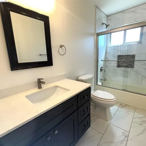 Modern vanity with a rectangular undermount sink, light-toned countertop, and dark-finish cabinetry
