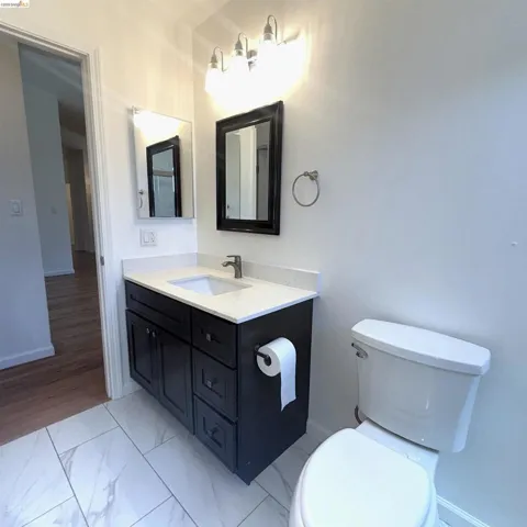 Bathroom featuring a dark wood-finish vanity with a light countertop, undermount sink, and brushed nickel faucet