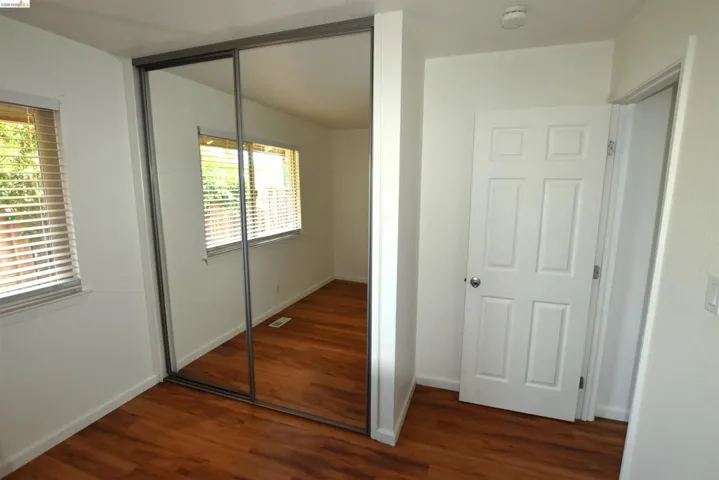 Expansive mirrored closet doors complement the wood-finish flooring