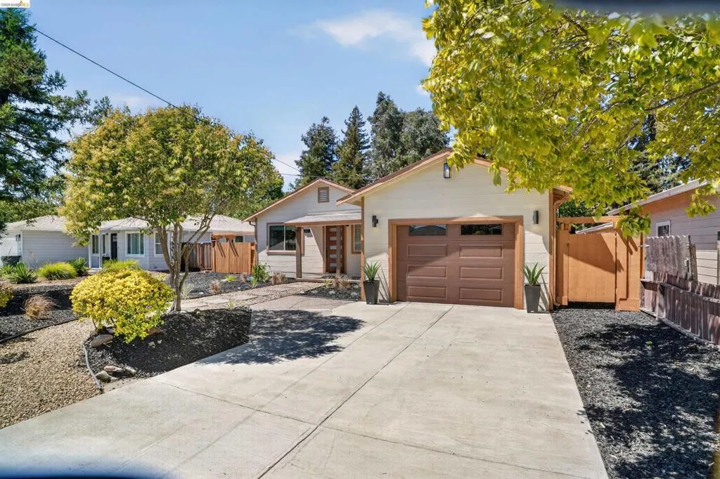Contemporary exterior with a light-colored facade, a brown garage door with frosted window panels, and a concrete driveway