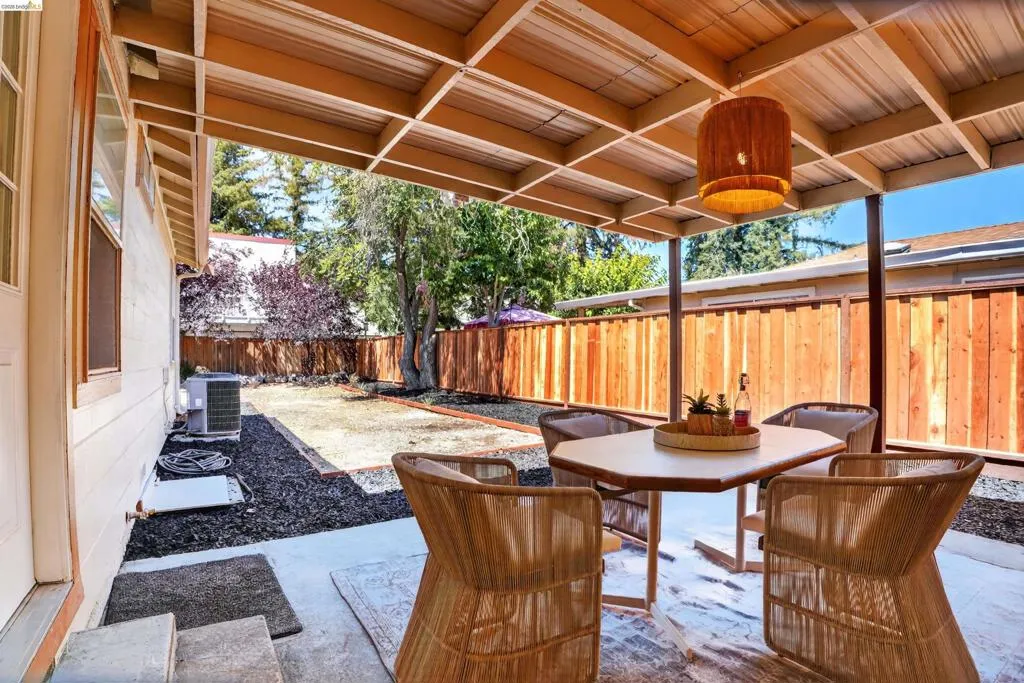 Covered patio with a wood-beam ceiling and suspended light fixture