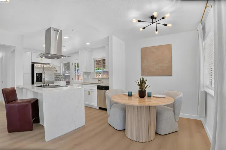 Bright kitchen and dining area featuring light wood-finish flooring