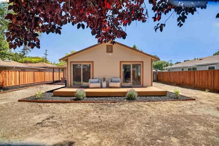 Rear facade featuring two sets of sliding glass doors opening onto a raised wood deck