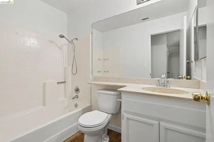 Bathroom featuring a white vanity with cabinet storage, an integrated sink, and a light-colored countertop