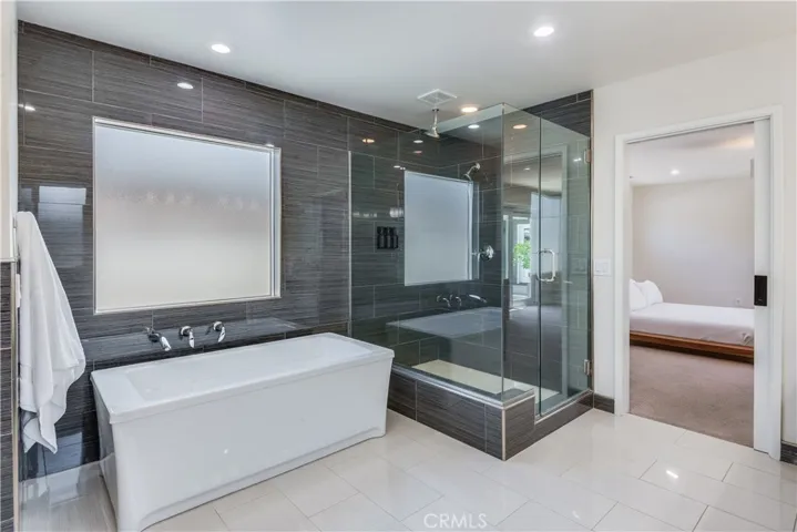 Primary en suite bathroom with soaking tub and separate shower