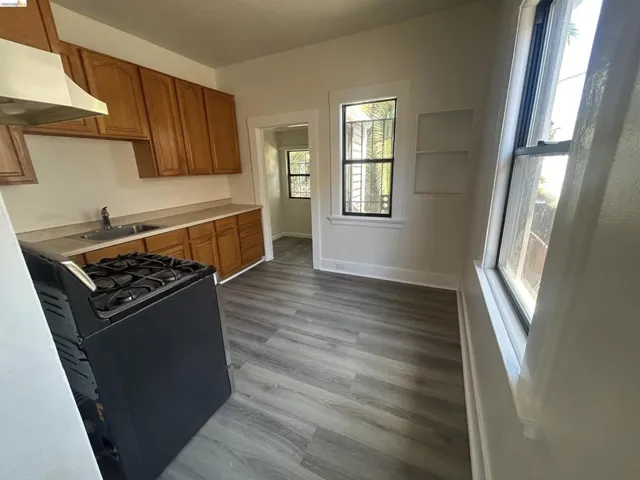 Kitchen featuring wood cabinetry, a stainless steel sink, and a black gas range