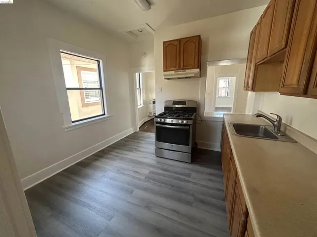 Kitchen featuring wood-finish flooring and a stainless steel gas range