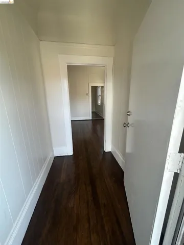 Entryway featuring dark wood-finish flooring, white paneled walls, and white trim
