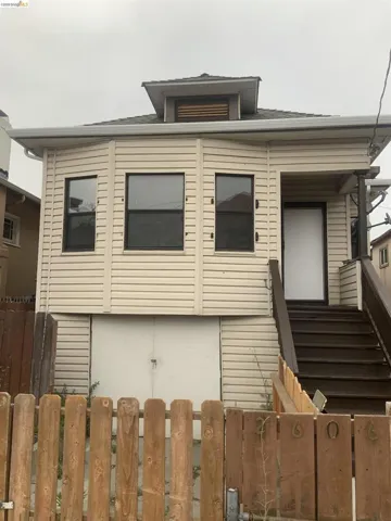Two-story exterior with horizontal siding, covered front entry, and black-framed windows